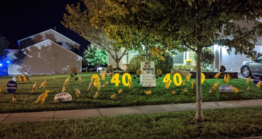Night yard display celebrating JJ's 40th birthday with dinosaur theme