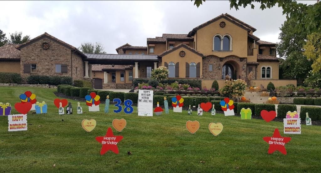 Tuscan style home with colorful birthday yard sign display for Kerri's 38th birthday