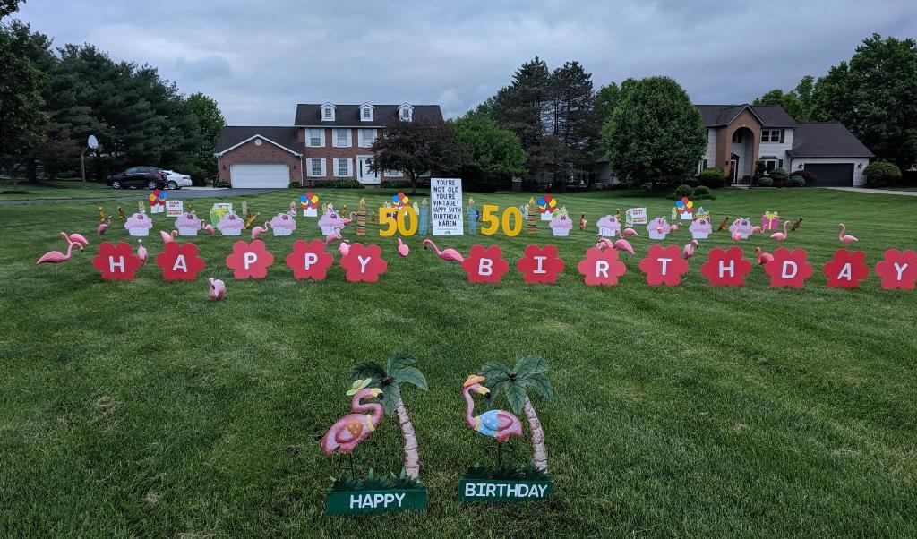 Large estate lawn with flamingos red flower letters spelling Happy Birthday for Karen's 50th