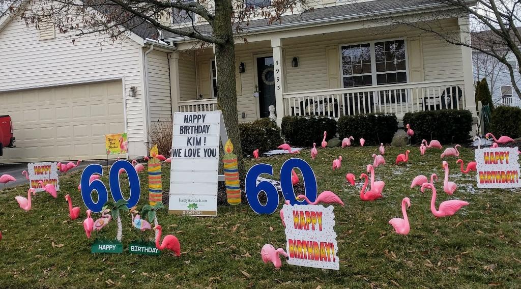 Tan ranch home with pink flamingos blue 60 signs and candles for Kim's 60th birthday