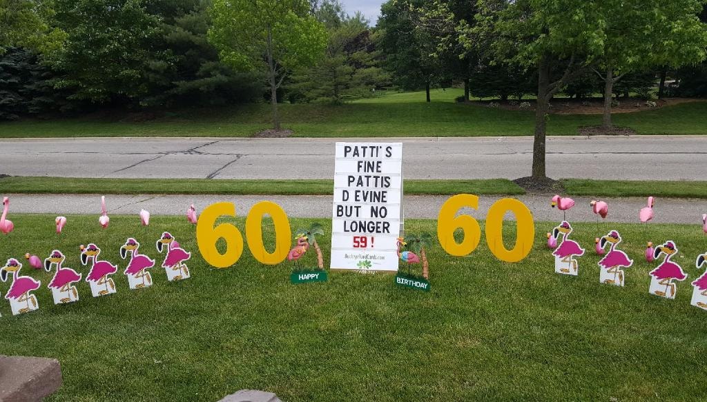 Large lawn with flamingos and gold 60 signs for Patti's 60th birthday