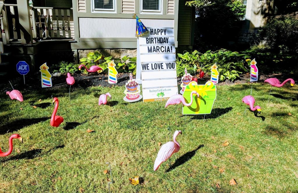 Front yard with pink flamingos cakes and candles for Marcia's birthday