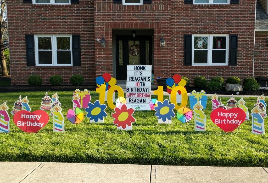 Brick home with colorful birthday yard signs for Reagan's 10th birthday