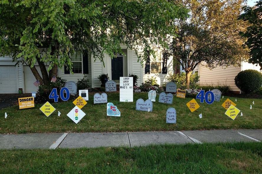 Front yard decorated with humorous road signs and tombstones for a 40th birthday