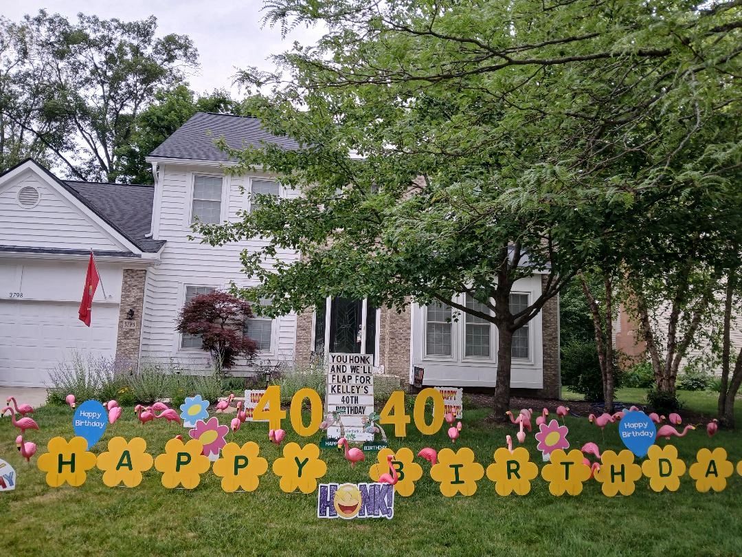 White house decorated with flamingo 40th birthday yard signs